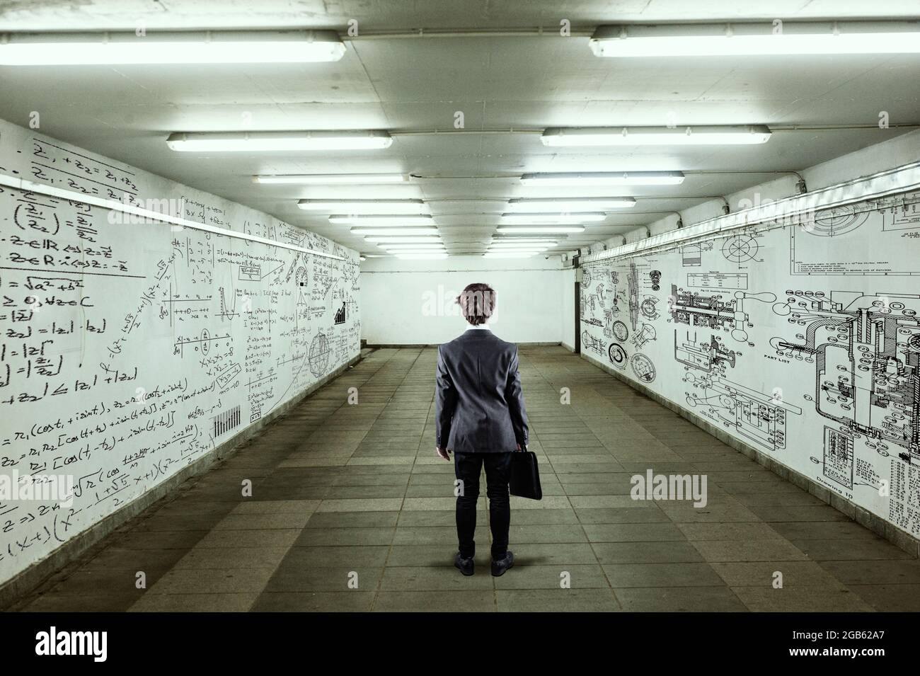 Geschäftsmann geht durch einen Tunnel mit Wänden voller mathematischer Formeln und Skizzen. Stockfoto