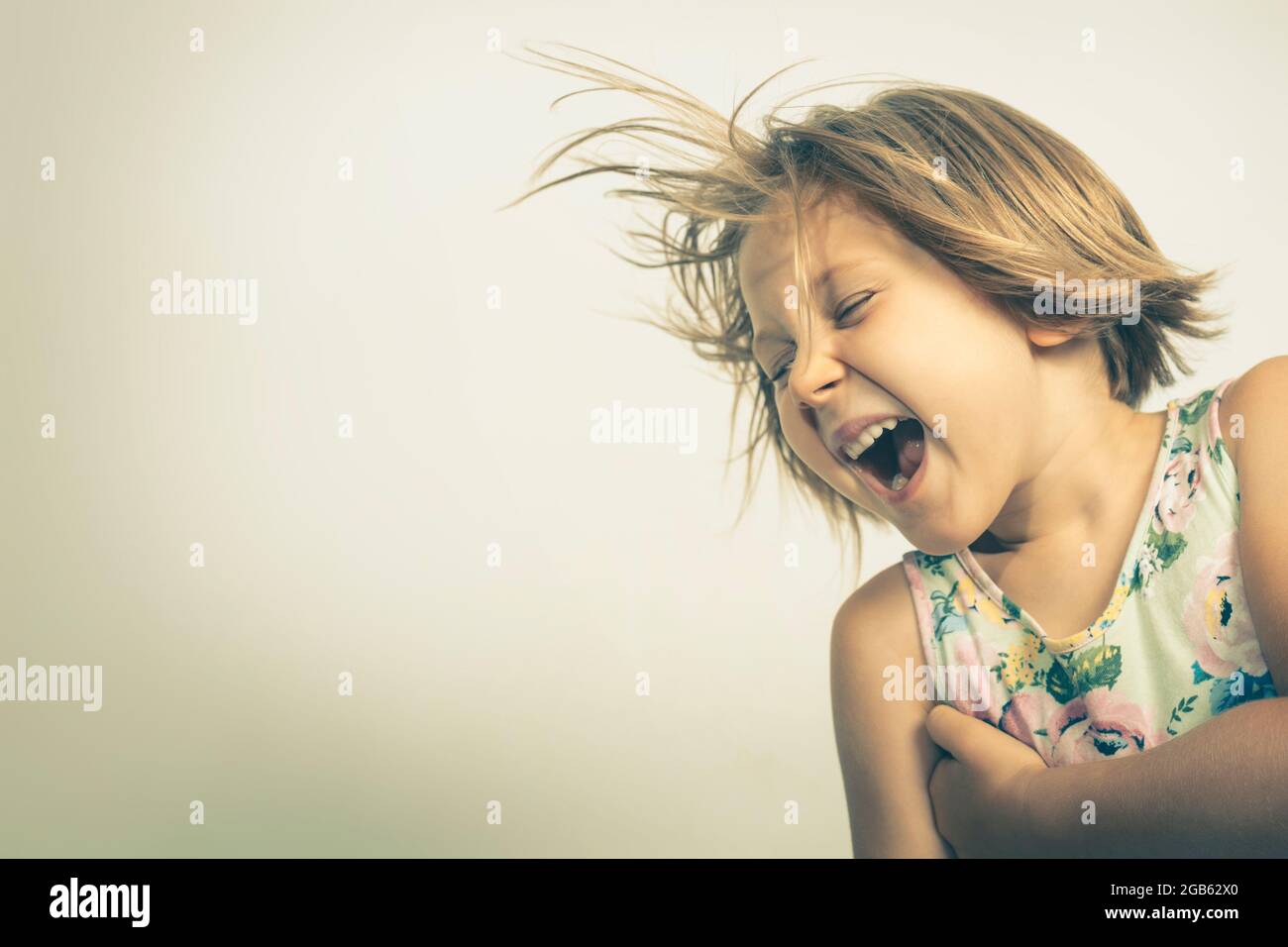 Fröhliches kleines Mädchen lacht sorglos. studioportrait Stockfoto