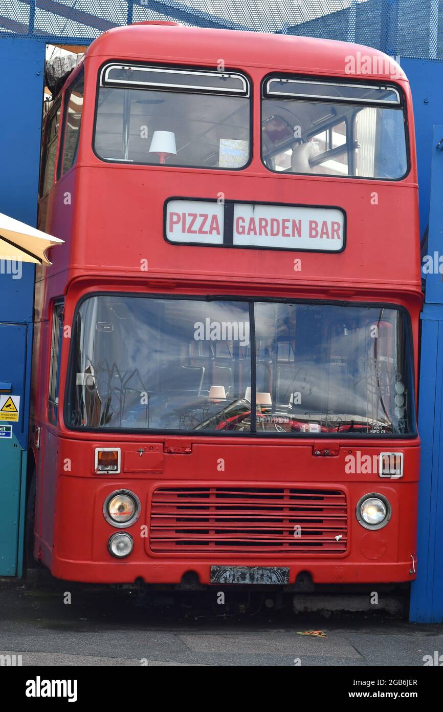 Ein roter Londoner Bus, der als Pizza-Restaurant und Gartenbar genutzt wird Stockfoto