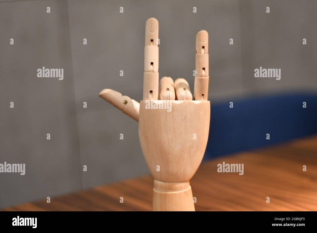 Eine hölzerne Hand, die mit dem Zeigefinger, einem kleinen Finger, in Anspielung auf eine Felsenikone, positioniert ist Stockfoto