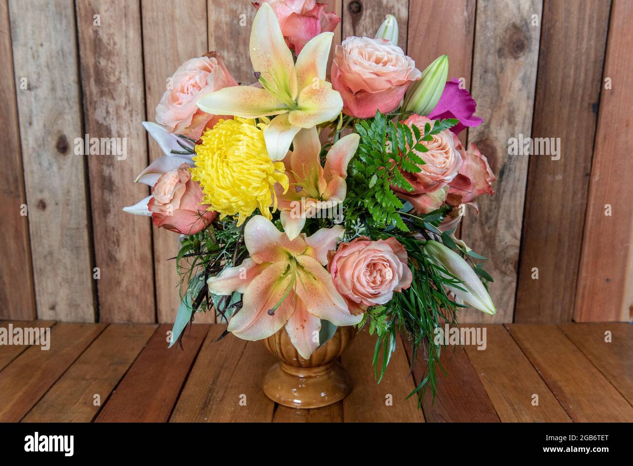 Schöner Strauß von arrangierten Rosen, Sternguchern und Mutterblumen in einer Vase mit noch zu öffnenden Blüten. Stockfoto