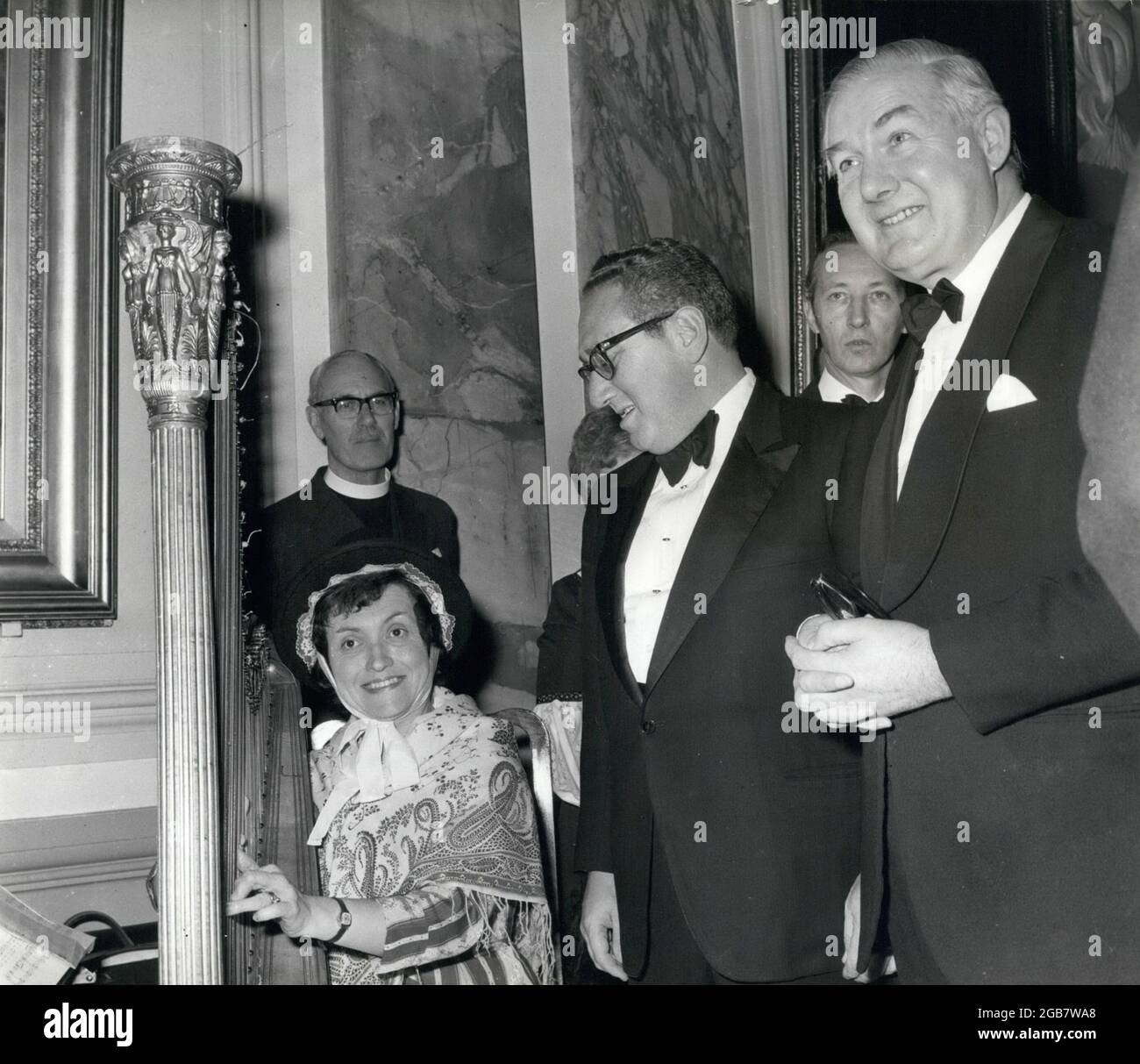 Cardiff, Wales, Großbritannien. März 1975. Dr. HENRY KISSINGER, mitten im Glas, der US-Außenminister, besuchte gestern Cardiff, wo er James CALLAGHAN, rechts, den britischen Außenminister, der die Freiheit der Stadt erhielt, sah, nach dem er an einem Bankett im Rathaus teilnahm. Dr. Kissinger und Mr. Callaghan, gesehen mit dem walisischen Harfenisten, bei einem Empfang, der vor dem letzten Bankett im Rathaus von Cardiff stattfand. Kredit: Keystone Presseagentur/ZUMA Wire/Alamy Live Nachrichten Stockfoto