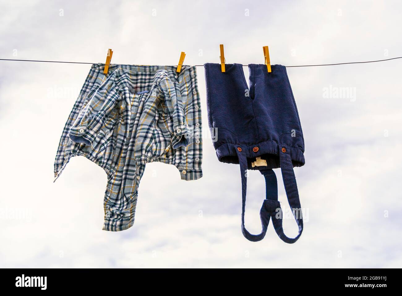 Elegante Babyhose und Hemd mit Holzzapfen gegen wolkiger Himmel Stockfoto