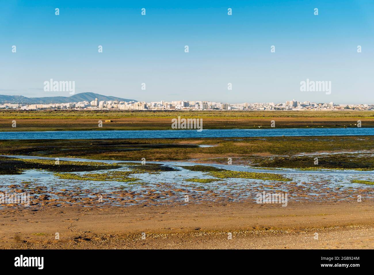 Stadt Faro von der Faro Beach Peninsula mit Feuchtgebieten der Ria Formosa dazwischen, Algarve, Portugal Stockfoto