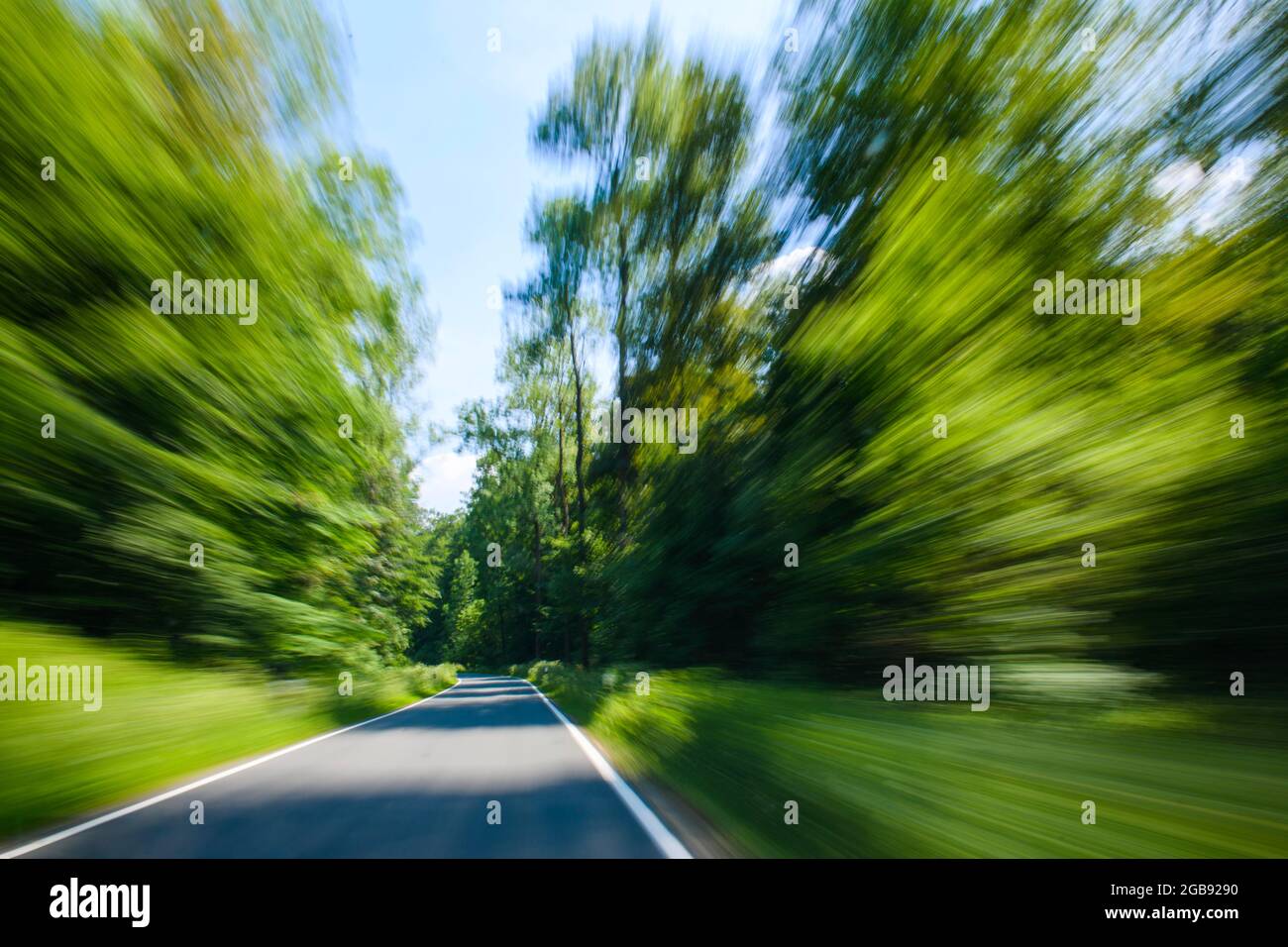 Blick durch die Windschutzscheibe eines fahrenden Autos auf kurvenreicher Landstraße, Weserbergland, Niedersachsen, Deutschland Stockfoto