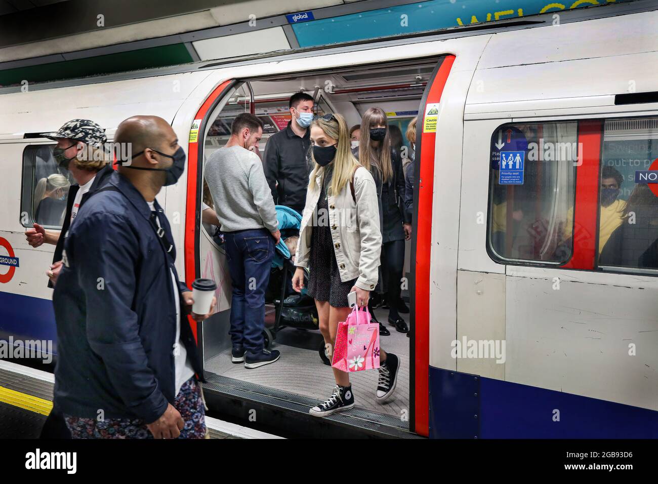 London, Großbritannien. Juli 2021. Die Passagiere verlassen in London einen stark frequentierten U-Bahn-Zug, der immer noch ihre Gesichtsmasken trägt. Trotz des Endes der gesetzlichen Pflicht zum Tragen von Gesichtsmasken in England ist das Tragen von Gesichtsmasken auf Londoner Transportmitteln weiterhin obligatorisch und die Menschen halten sich weiterhin an die Vorschriften. (Foto von Martin Pope/SOPA Images/Sipa USA) Quelle: SIPA USA/Alamy Live News Stockfoto