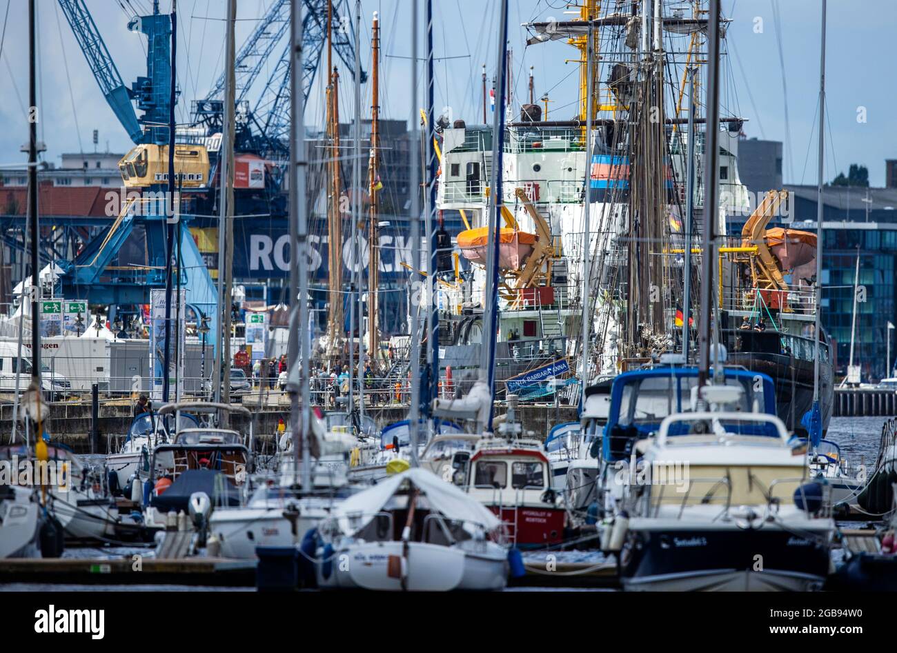 Rostock, Deutschland. August 2021. Segelboote und traditionelle Schiffe liegen im Stadthafen. Trotz koronabezogener Einschränkungen und Besucherbeschränkungen für zentrale Veranstaltungsorte versprechen die Veranstalter der 30. Hanse Sail in Rostock wieder ein maritimes Volksfest mit vielen Highlights. Quelle: Jens Büttner/dpa-Zentralbild/dpa/Alamy Live News Stockfoto