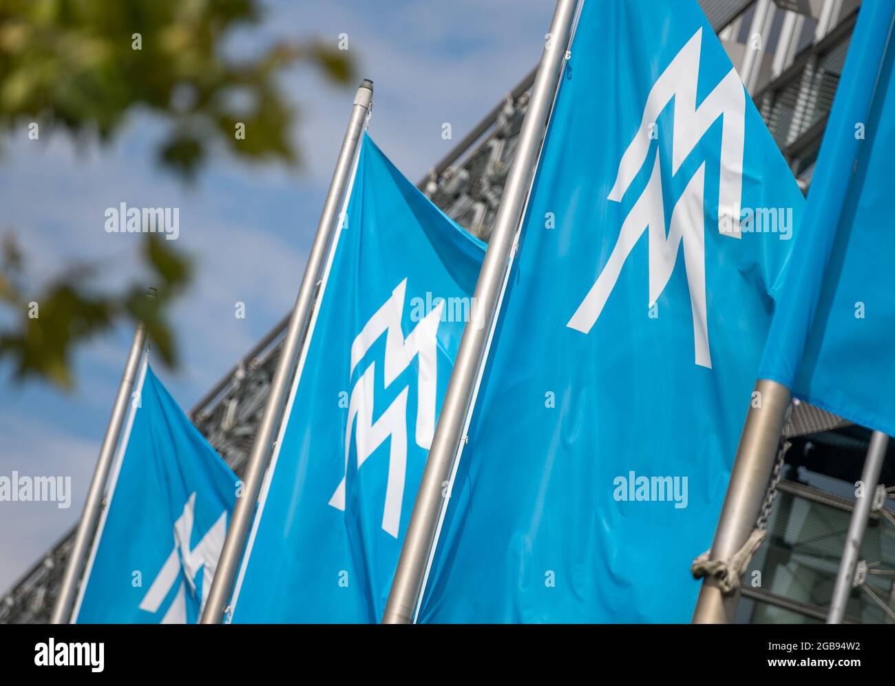 Leipzig, Deutschland. August 2021. Vor dem Verwaltungsgebäude fliegen Fahnen mit dem Logo der Messe Leipzig. Das Messegeschäft in Sachsen, Sachsen-Anhalt und Thüringen beginnt wieder. Quelle: Hendrik Schmidt/dpa-Zentralbild/dpa/Alamy Live News Stockfoto