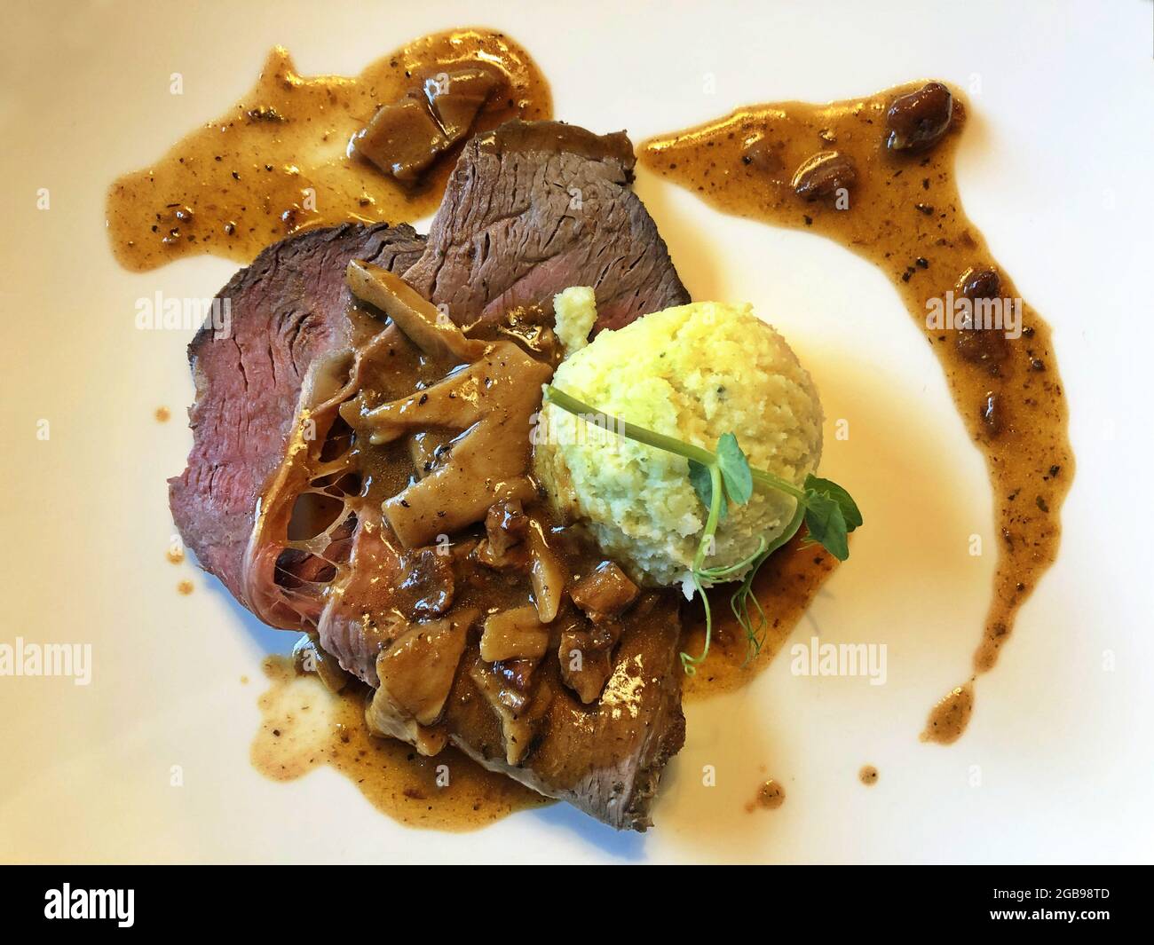 Aus der Perspektive von Rindfleisch garnieren Sie das Fleisch mit Pilzen und Kartoffeln Stockfoto