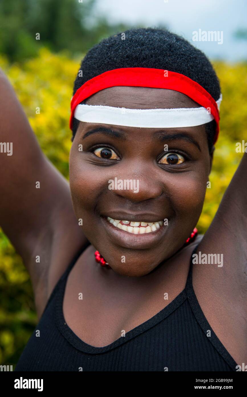 Frau, die bei einer Zeremonie ehemaliger Wilderer im Virunga-Nationalpark in Ruanda, Afrika, die Kamera anstarrte Stockfoto