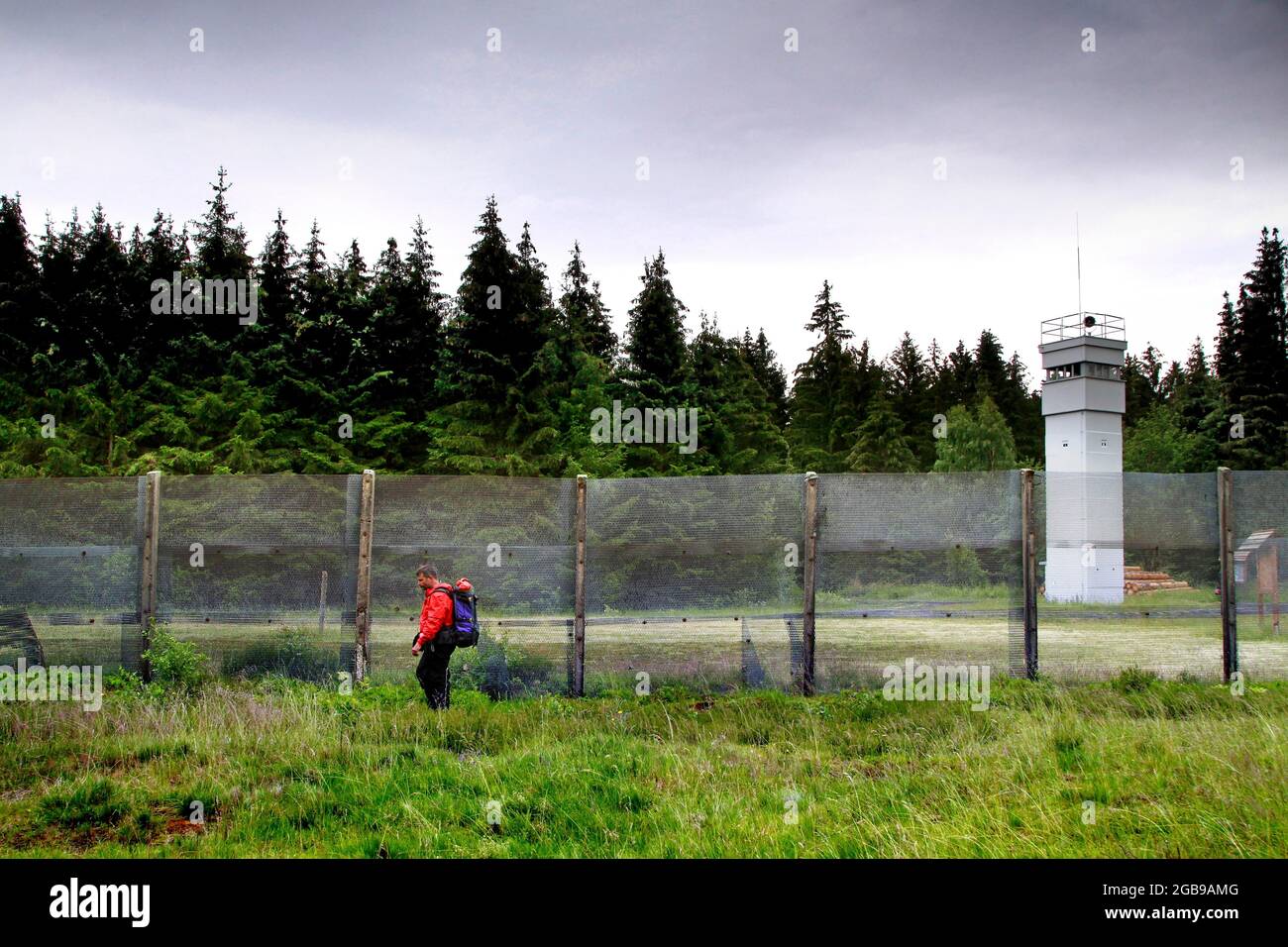 Wanderer, Mann mit Rucksack an der ehemaligen deutsch-deutschen Grenze, Grenzbarriere mit Beobachtungsturm der Grenztruppen der DDR, Grenzwachturm Stockfoto