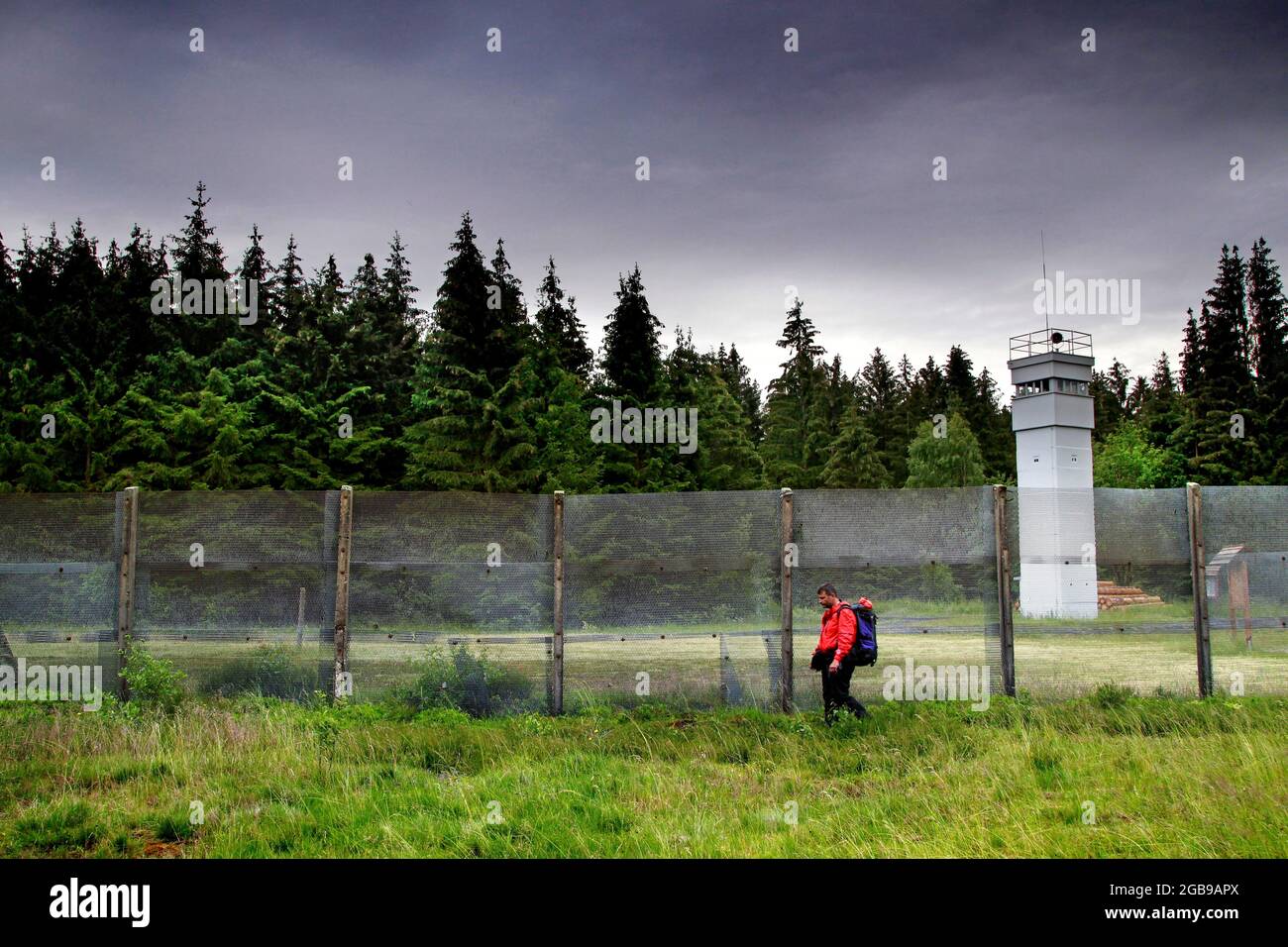 Wanderer, Mann mit Rucksack an der ehemaligen deutsch-deutschen Grenze, Grenzbarriere mit Beobachtungsturm der Grenztruppen der DDR, Grenzwachturm Stockfoto