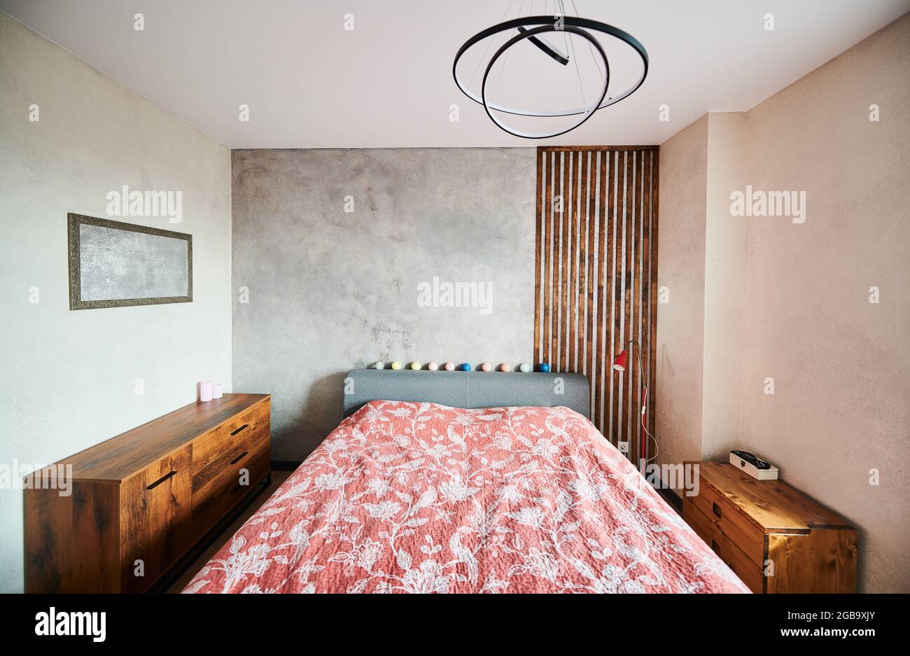 Vorderansicht der modernen Wohnung in weichen warmen Farben, großes Schlafzimmer und stilvolle braune Nachttische. Konzept der modernen Innenausstattung geräumiges Schlafzimmer mit schönen Möbeln. Stockfoto