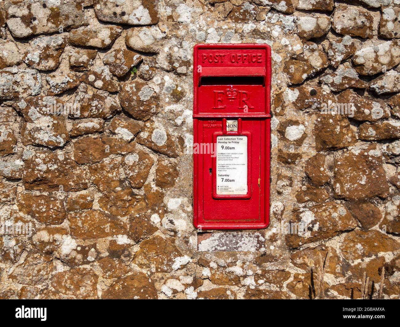 Royal Mail Briefkasten in einer alten Steinmauer, im Dorf Old Hunstanton, Norfolk, Großbritannien Stockfoto