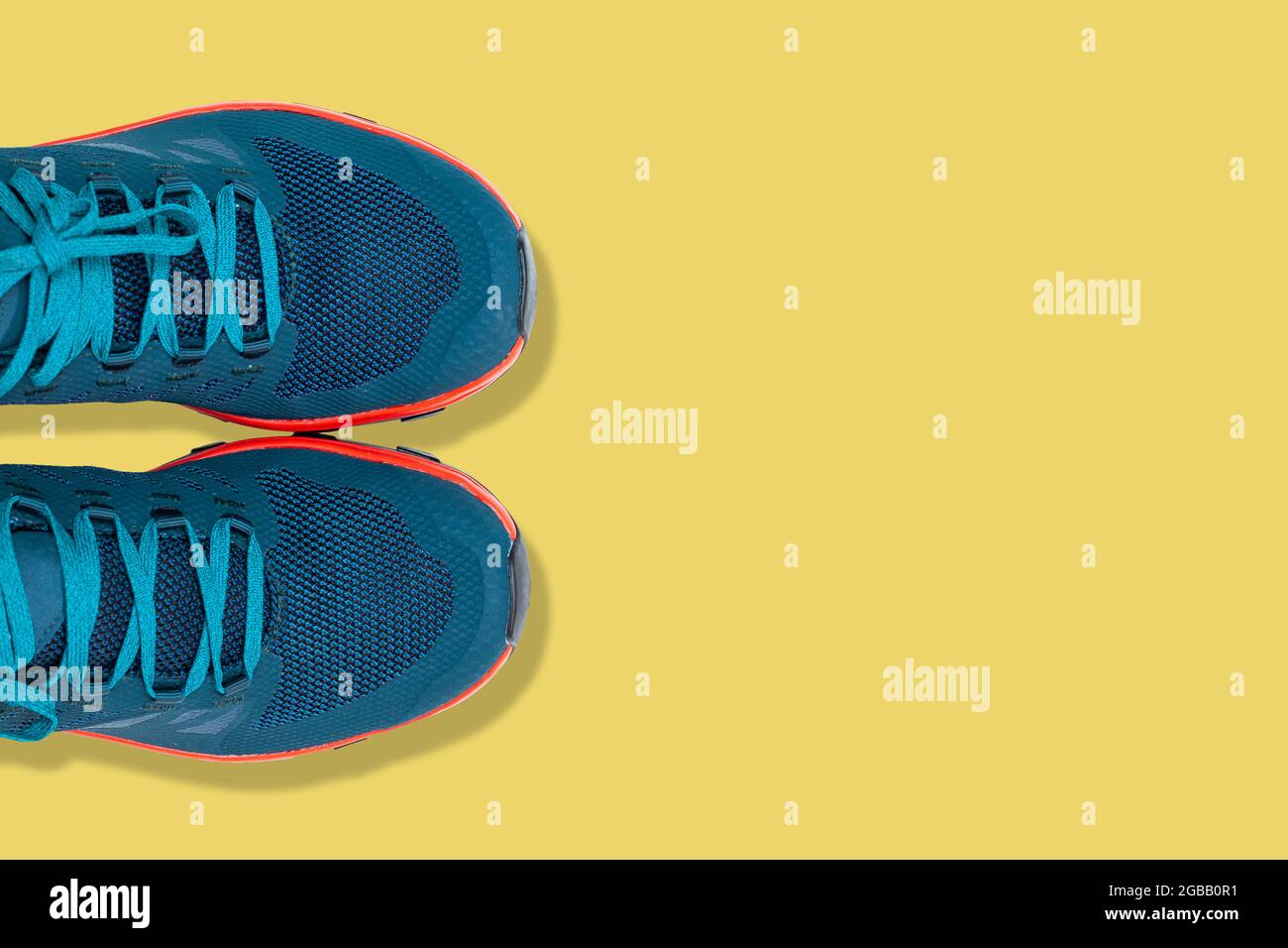 Blaue Sneaker auf gelbem Hintergrund Stockfoto