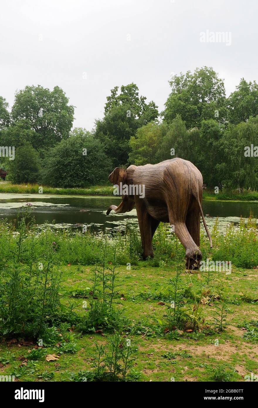 Elefantenskulptur aus invasiven Pflanzen, die auf dem Weg zum Wasser aus einem See in einem Park gesehen werden Stockfoto