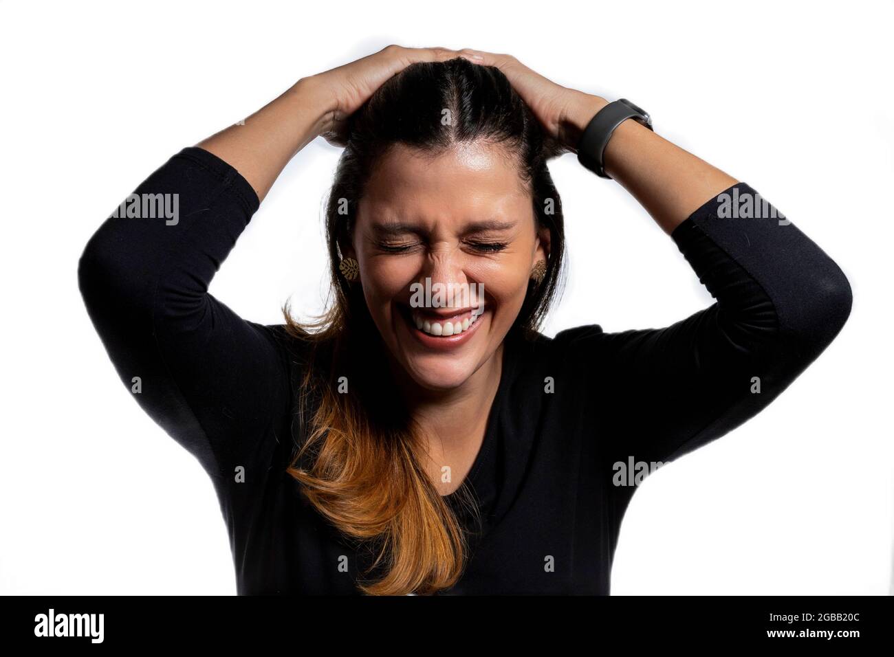 Fröhliche Latina-Frau, die mit den Händen im Kopf lacht Stockfoto
