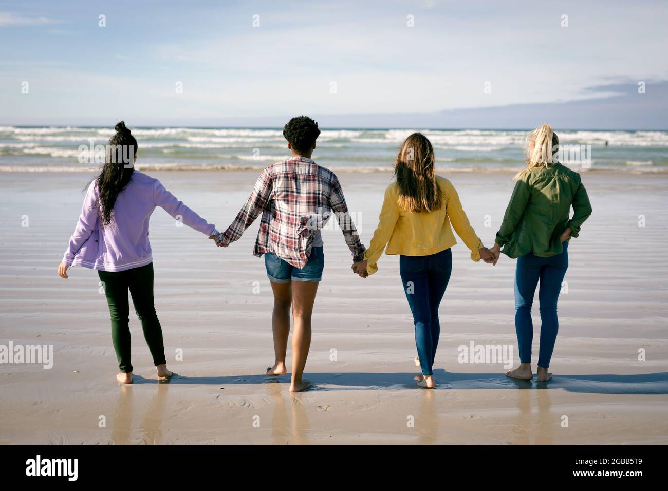 Eine Gruppe Verschiedener Freundinnen Die Sich Die Hände Hielten Und Am Strand Entlang Gingen 