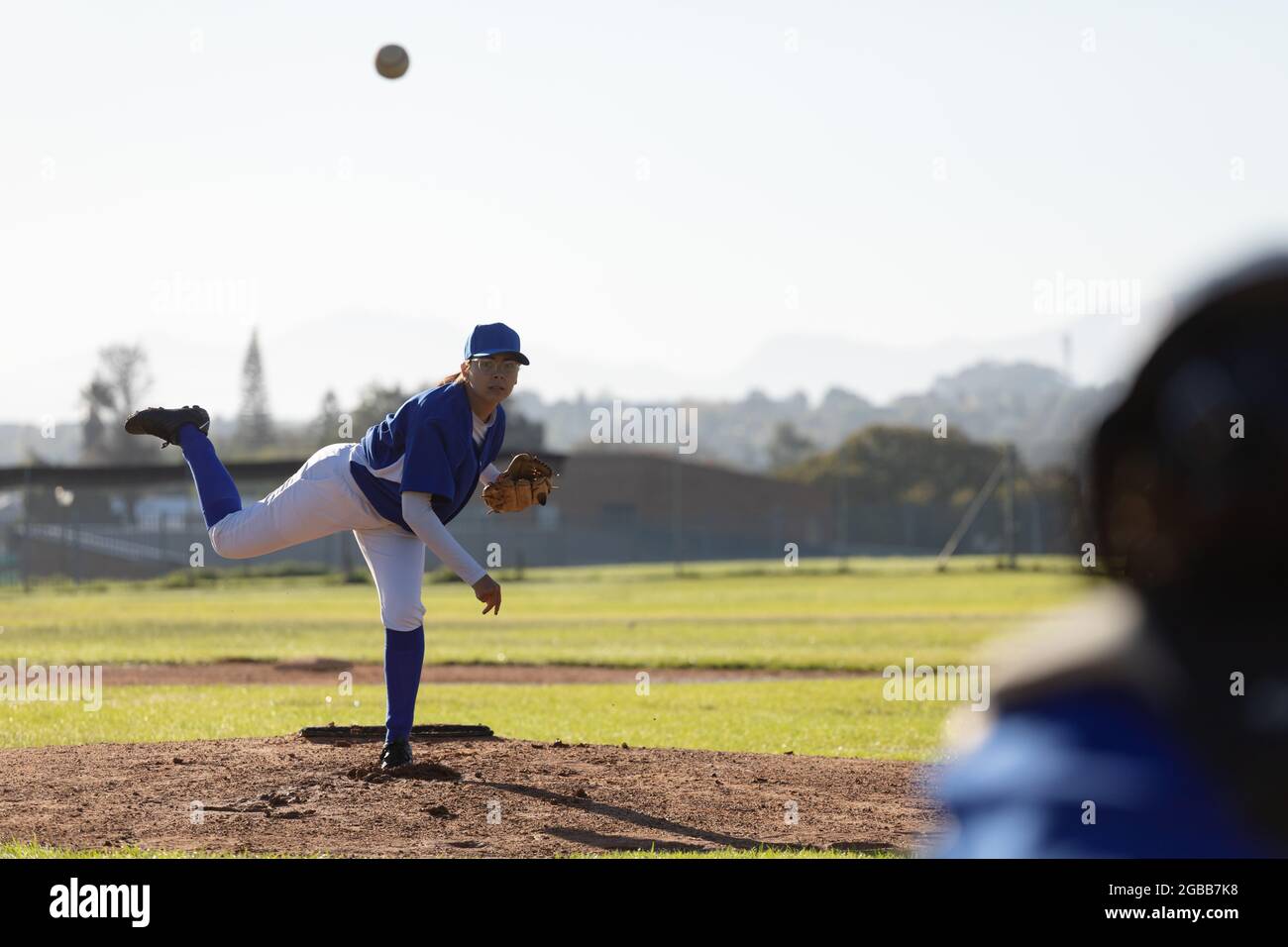 Gemischtes Rennen weibliche Baseballkrug auf sonnigen Baseballfeld werfen Ball während des Spiels Stockfoto