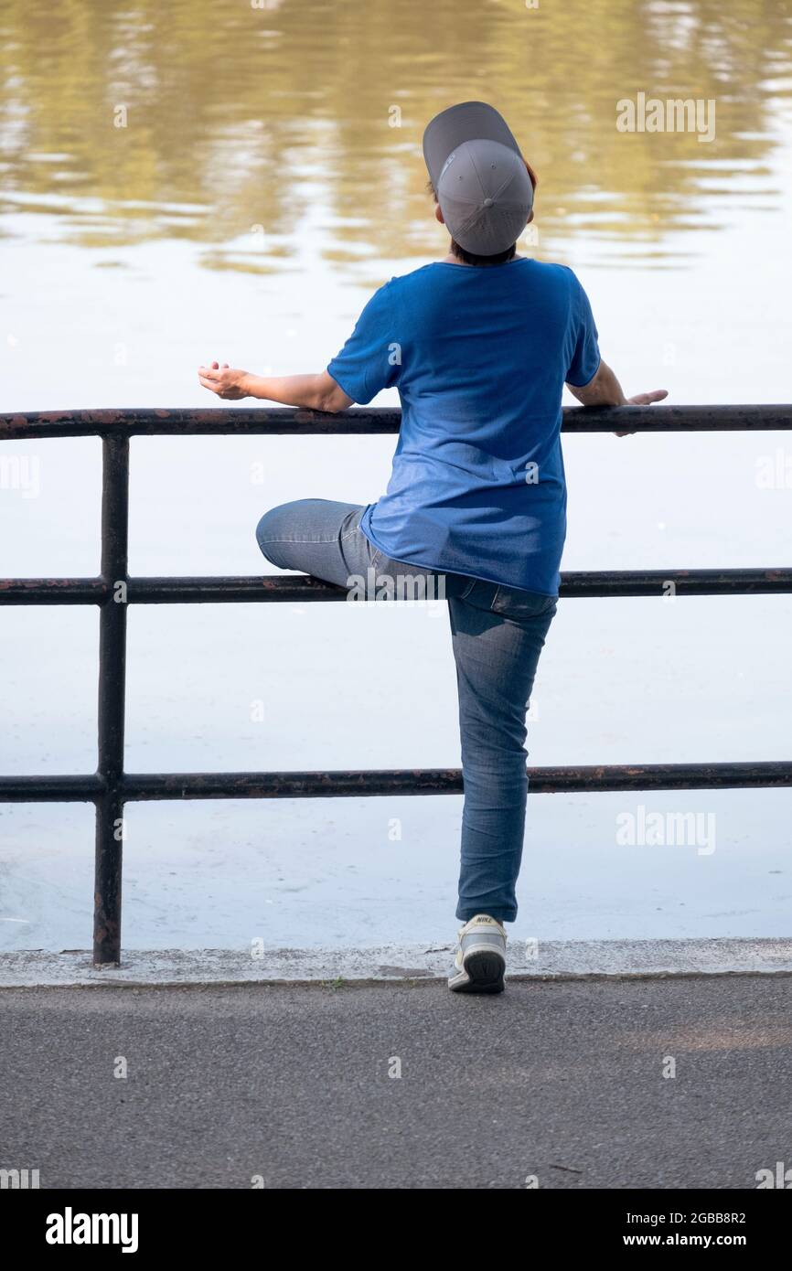 Vor dem Training streckt eine Frau ihr linkes Bein, während sie ihre Arme in einer Yoga-ähnlichen Position ausstreckt. In einer Arche in Queens, New York City. Stockfoto