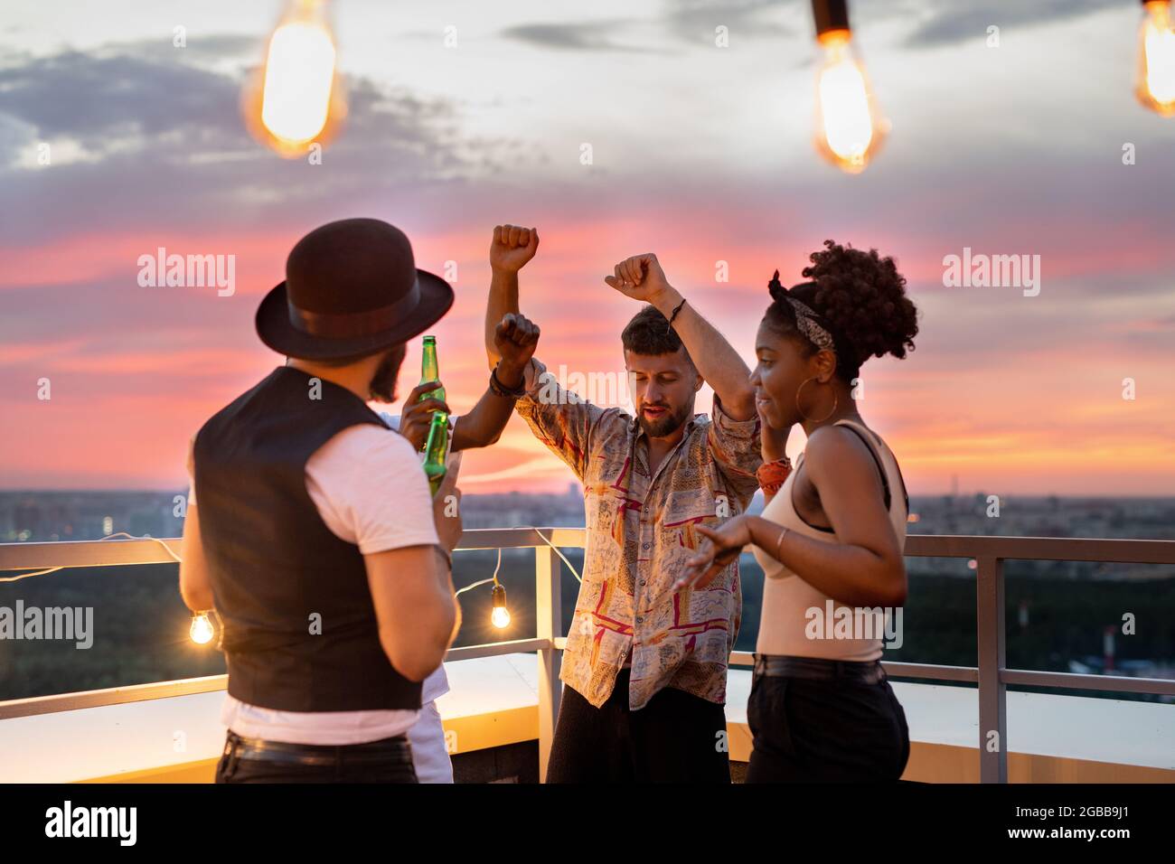 Eine Gruppe junger Leute tanzt und Bier auf der Dachterrasse Stockfoto