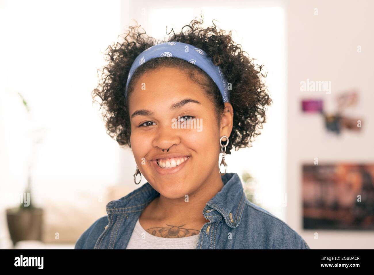 Hübsche weibliche Teenager in Casualwear, die Sie mit toothy Lächeln anschaut Stockfoto