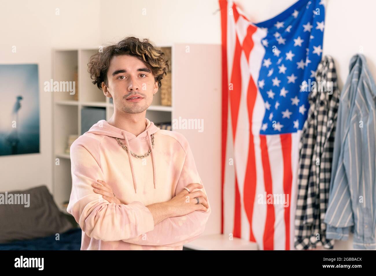 Ein amerikanischer Teenager mit einer Casualwear, der sich Brust für Brust gegen sein Schlafzimmer kreuzte Stockfoto
