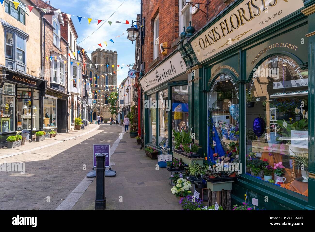 Blick auf Geschäfte und Cafés auf Kirkgate und Cathedral im Hintergrund, Ripon, North Yorkshire, England, Vereinigtes Königreich, Europa Stockfoto