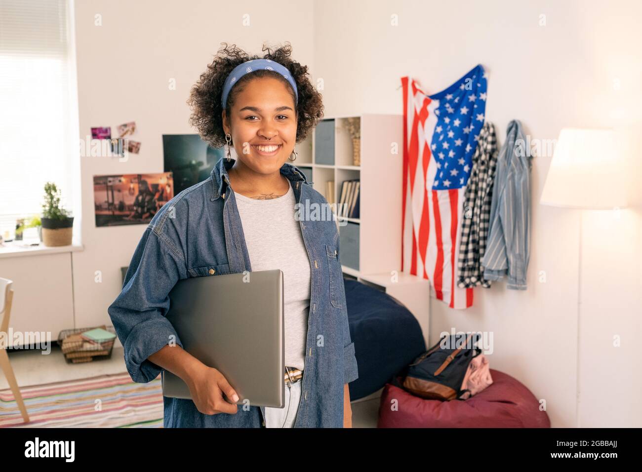Fröhliche amerikanische Teenager mit Laptop im Schlafzimmer Stockfoto