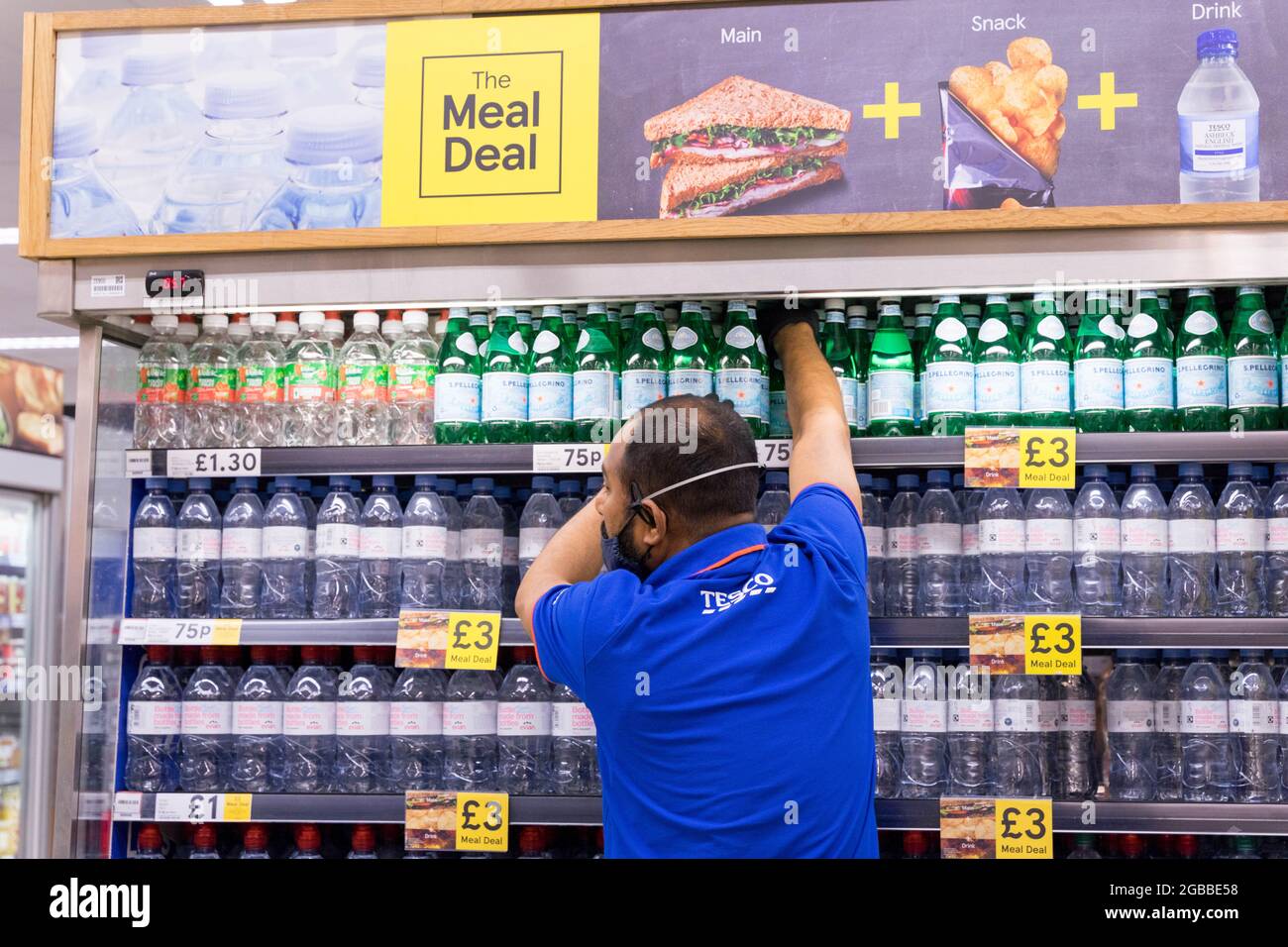 Supermarkt Tesco Mitarbeiter bereiten das Regal für Mahlzeiten Deal in £3 Stockfoto