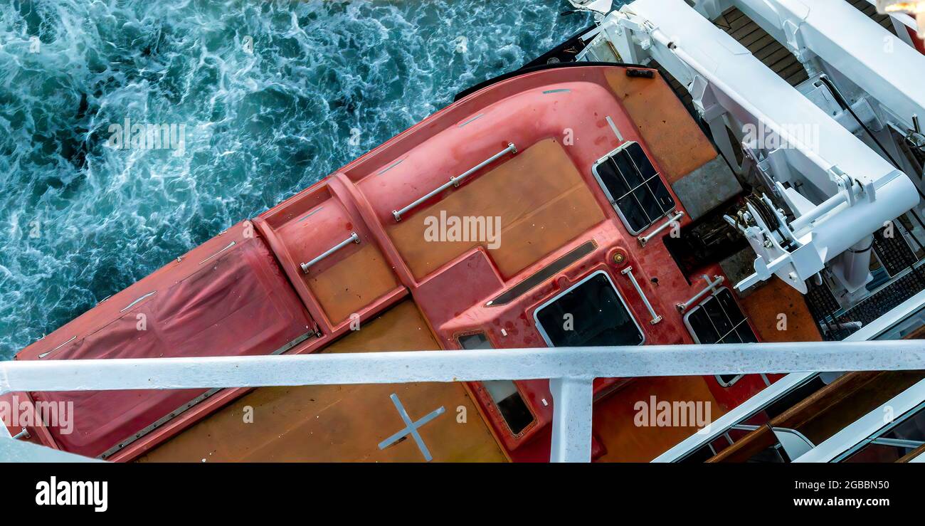 Ein Rettungsboot auf der NV Nieuw Amsterdam, von oben gesehen, mit dem turbulenten Meer unten. Stockfoto
