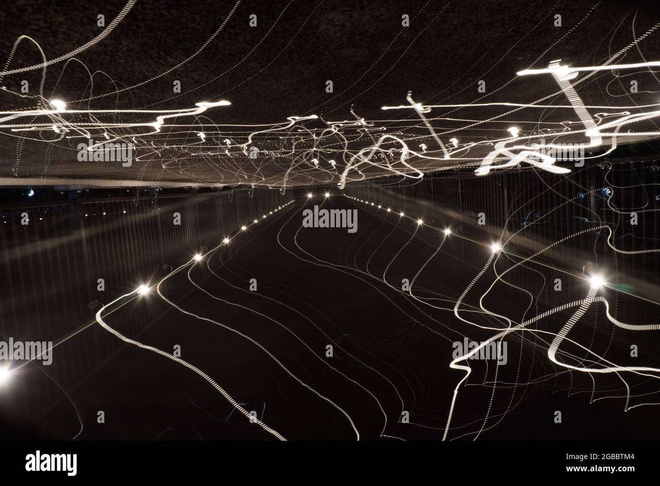 Verschwommene, abstrakte Lichtspuren auf einer Straße in der Nacht. Stockfoto