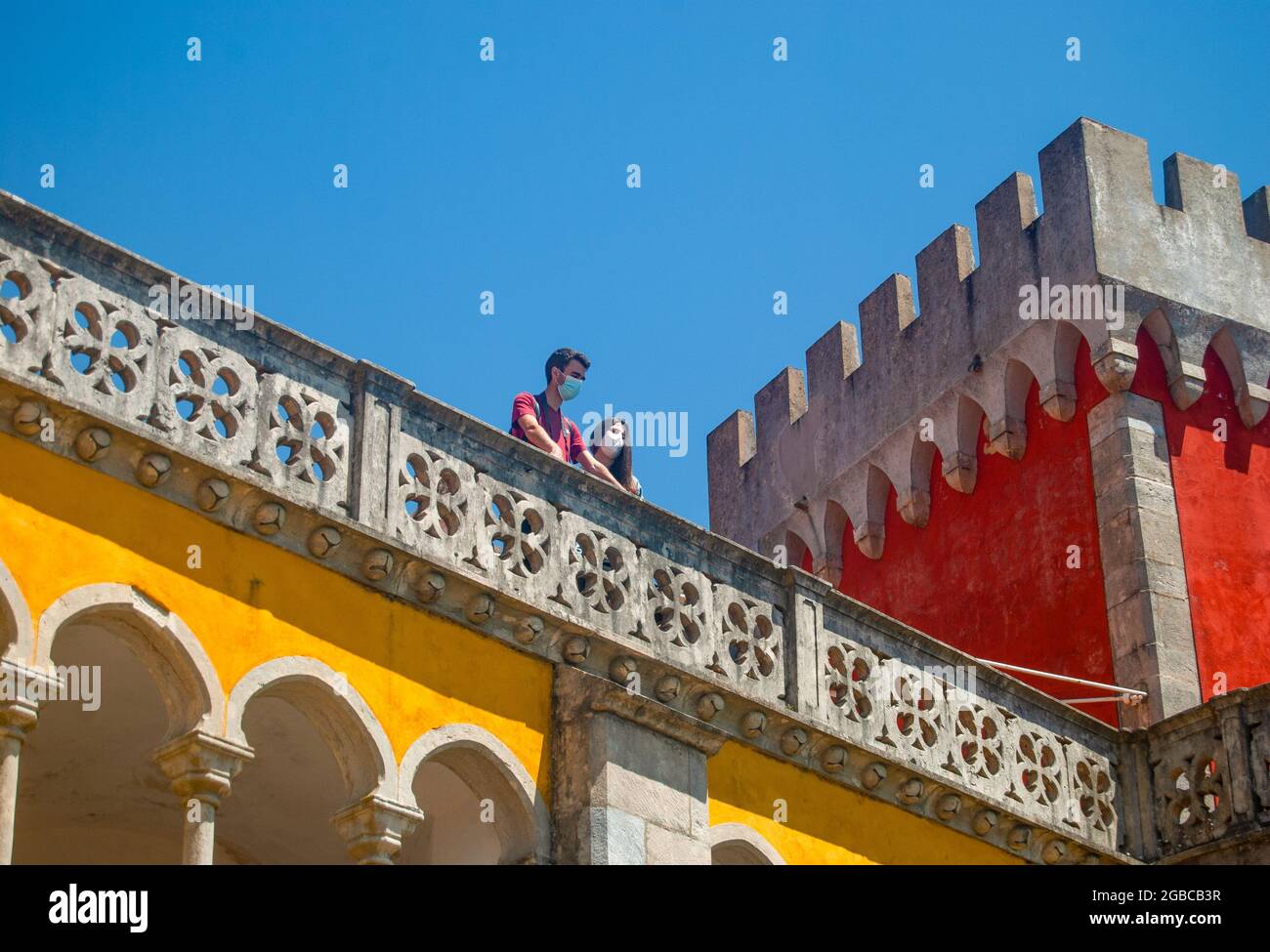 Eine Frau und ein Mann blicken auf den wunderschönen balkon im maurischen Stil des romantistischen Turms, der gelb und rot gefärbt ist Stockfoto
