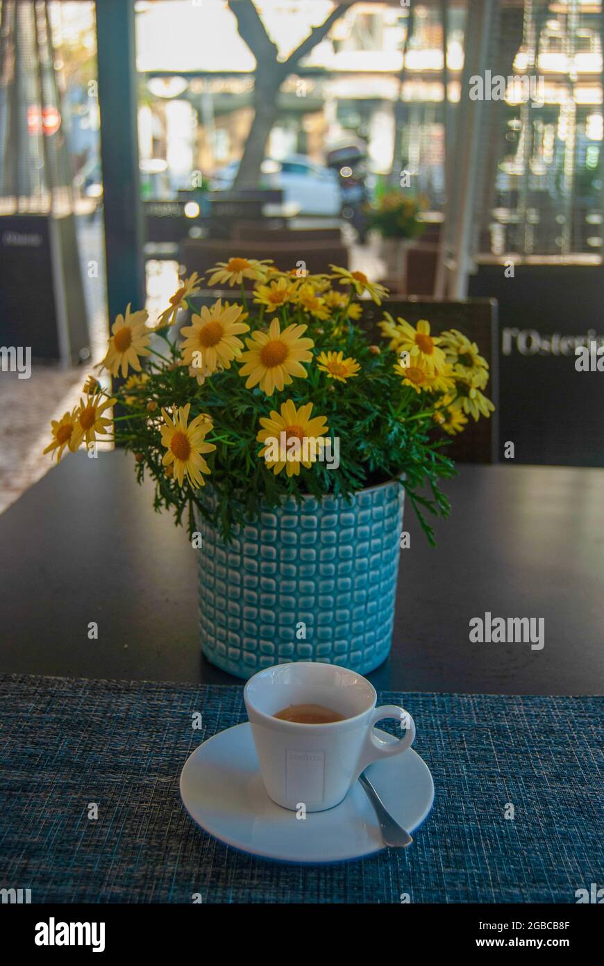 Tasse portugiesischer Espresso am Morgen ist der Tisch mit Blumen geschmückt Stockfoto