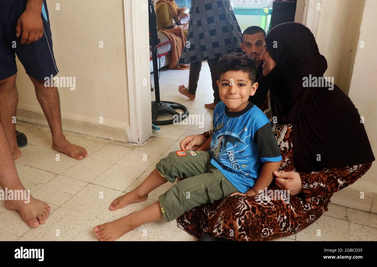 Der 4-jährige Walid liegt am 1. August 2021 zu Hause am Hafen von Beirut, Libanon, auf dem Schoß seiner Mutter. Im letzten Save the Children Report über den Libanon heißt es: „die Wirtschaftskrise hat Familien aller sozioökonomischen Ebenen und Nationalitäten getroffen, aber syrische Flüchtlinge gehören zu den am stärksten betroffenen.“ Walid ist das zweitletzte von elf Kindern einer Flüchtlingsfamilie aus Syrien. Mutter, Vater, Kinder, der Ehegatte des ersten Kindes und ihre beiden Kinder leben alle in einer 2 Zimmer-Wohnung am Hafen. Auf wundersame Weise überlebten sie alle die Explosion vom 4 2020. August, aber nach dem Vorfall überlebte der Chef der fam Stockfoto