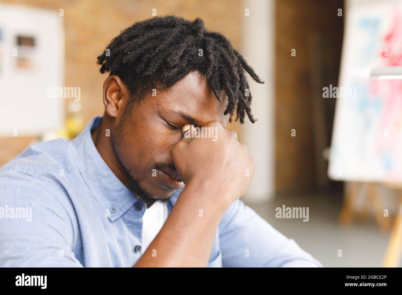 Müde afroamerikanische Malerin bei der Arbeit im Kunststudio Stockfoto
