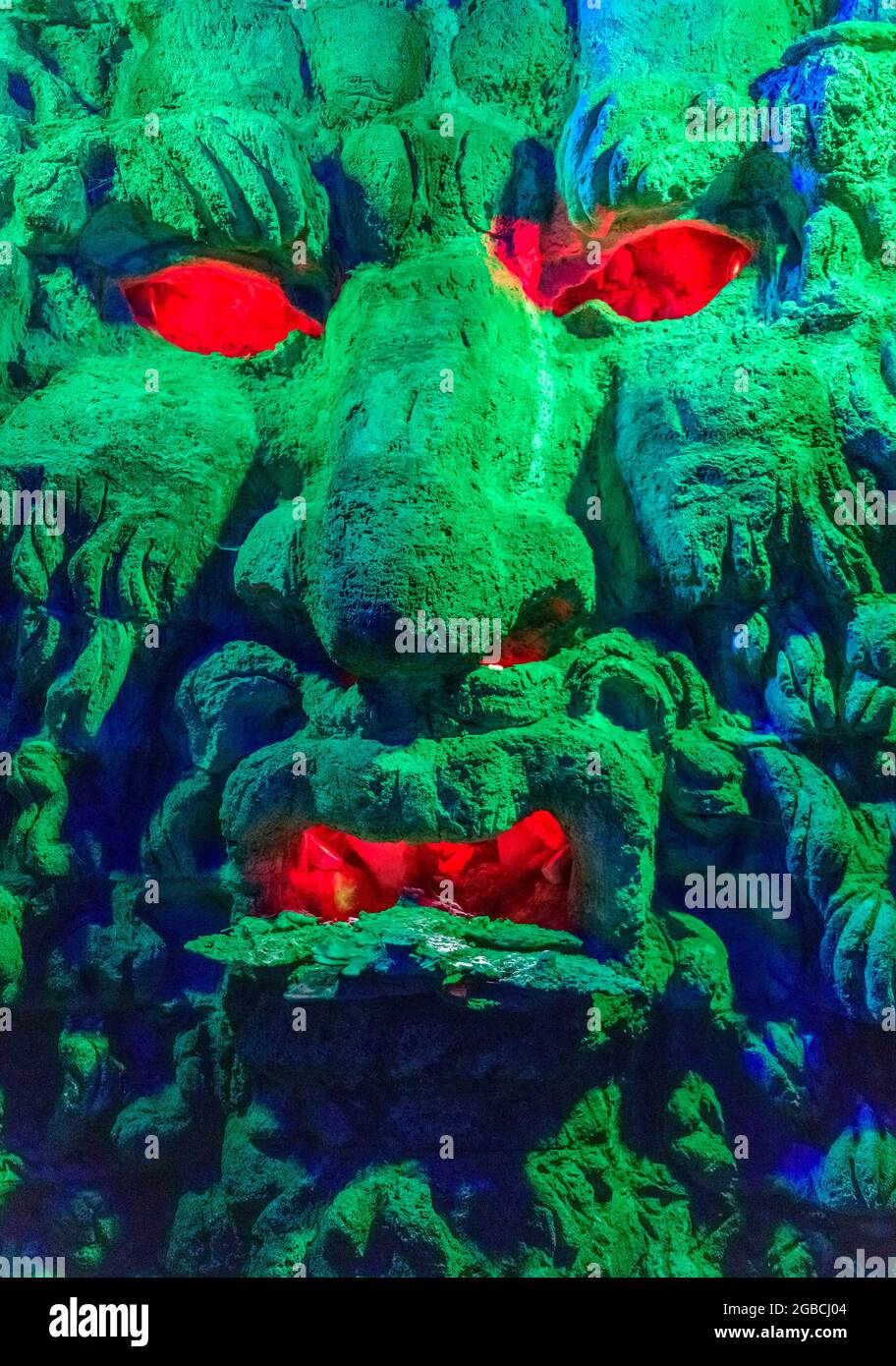 Groteske grüne Monster Kopf mit roten Augen und Mund. Gefunden in der Grotte unter dem Labyrinth in Leeds Castle kent england Stockfoto