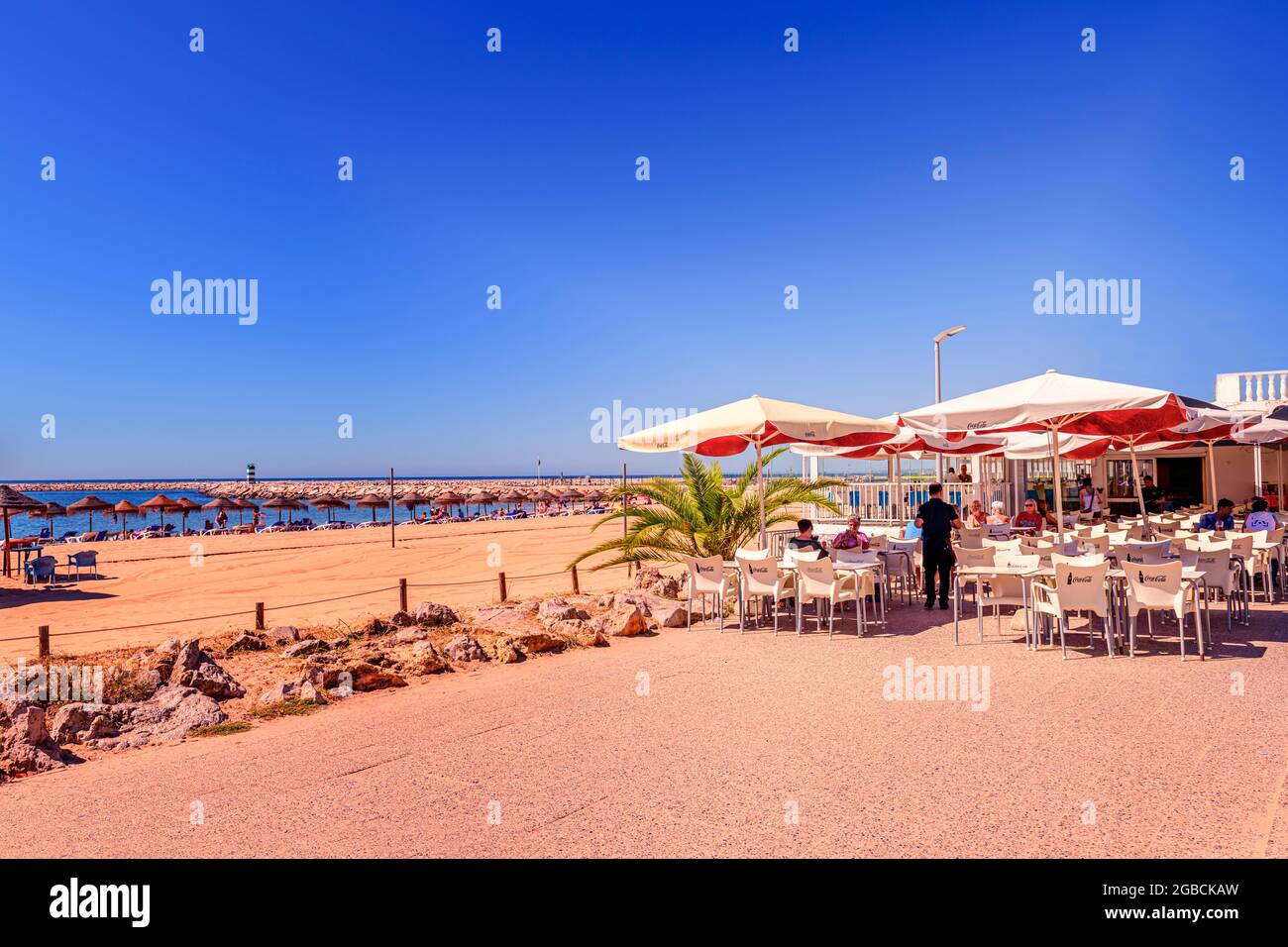 Strandrestaurant-Café am strand praia rosa branca Quarteira mit Sonnenschirmen und Liegestühlen im Hintergrund. Quarteira algarve Portugal Stockfoto