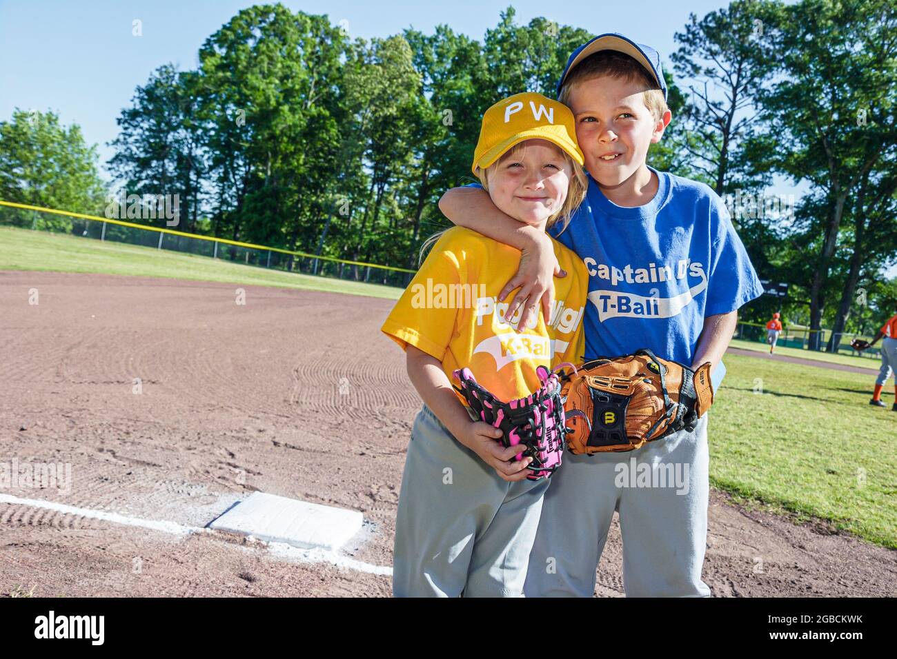 Alabama Monroeville Veterans Park Little League Baseballspieler, junge Mädchen Kinder Bruder Schwester Geschwister in Uniformen umarmt, Stockfoto