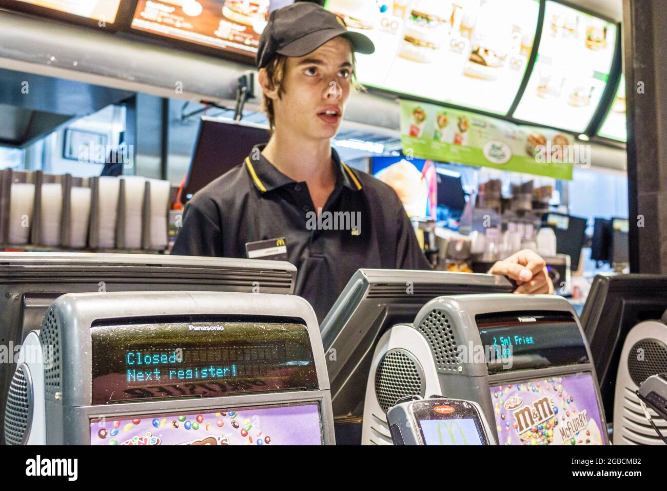 Sydney Australien, Bondi McDonald's Restaurant Fast-Food-Kasse, jugendlicher Teenager, junger, männlicher Angestellter, der die Arbeit übernimmt, insid Stockfoto