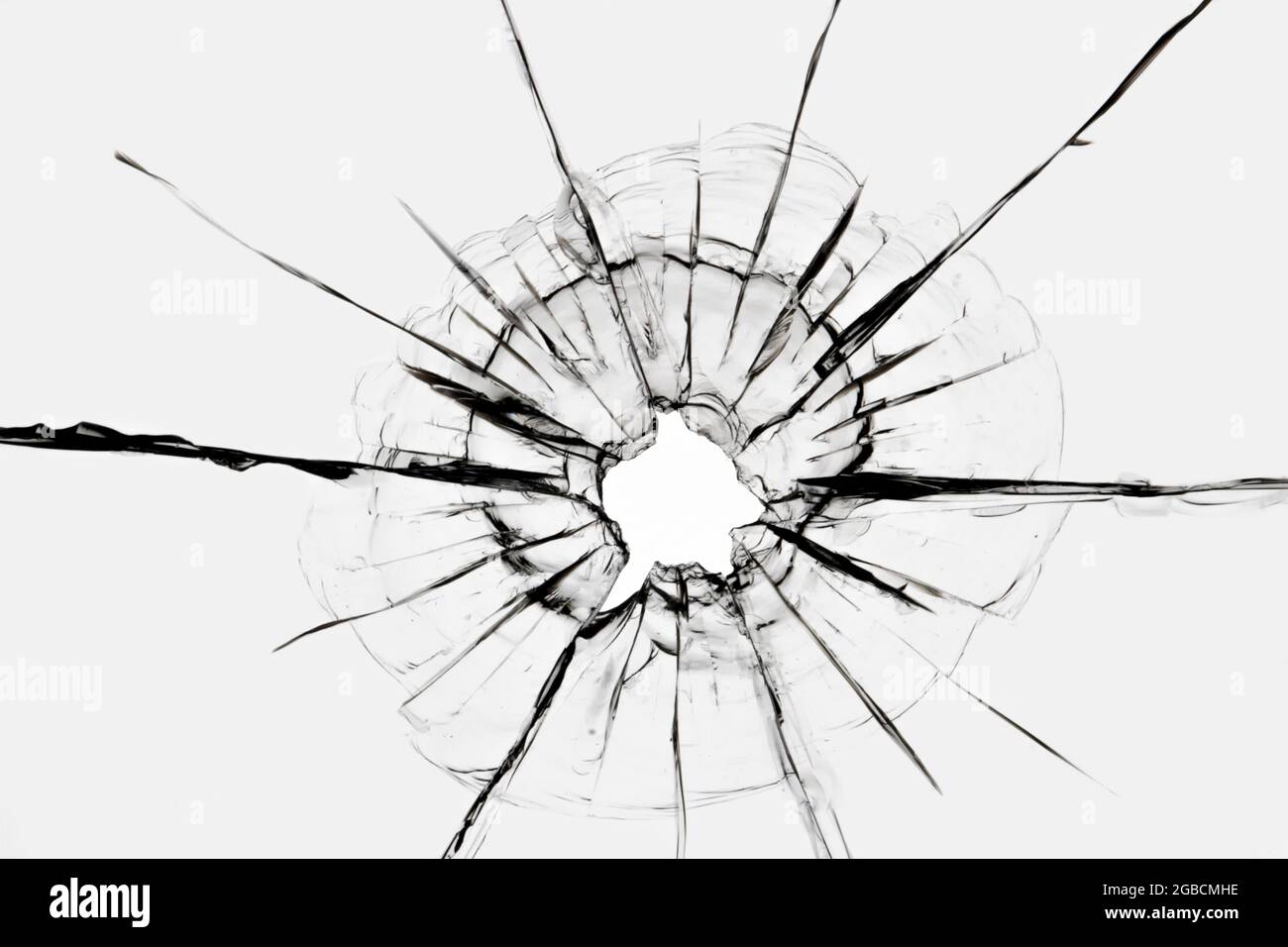 Risse im Fenster von einem Schuss aus einer Waffe. Beschädigtes Fensterglas. Stockfoto