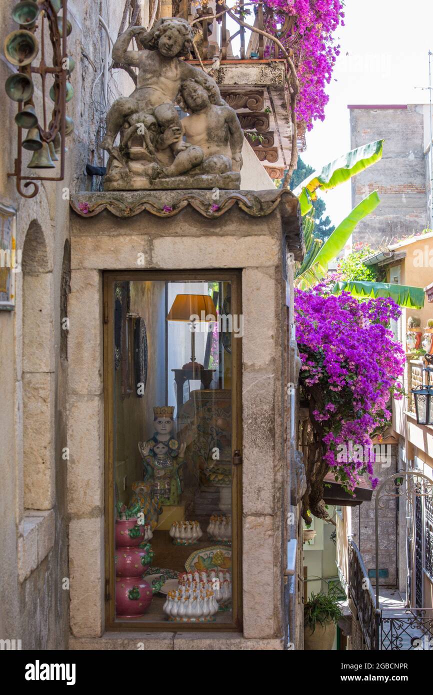 Taormina, Messina, Sizilien, Italien. Typische, mit Blumen gefüllte Gasse am Corso Umberto I, Antiquitätengeschäft façade, drapiert in rosa Bougainvillea. Stockfoto