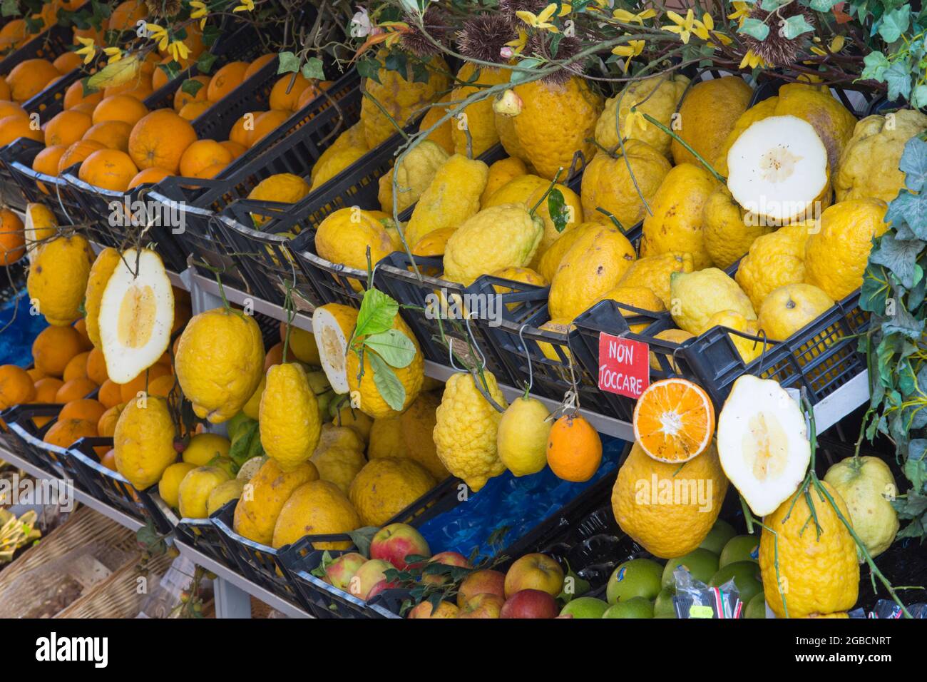 Taormina, Messina, Sizilien, Italien. Typische Zitrusfrüchte, die vor dem Laden des Gemüsehaums in der Altstadt ausgestellt werden, ganze und abgeteilte Zitronen sind prominent. Stockfoto
