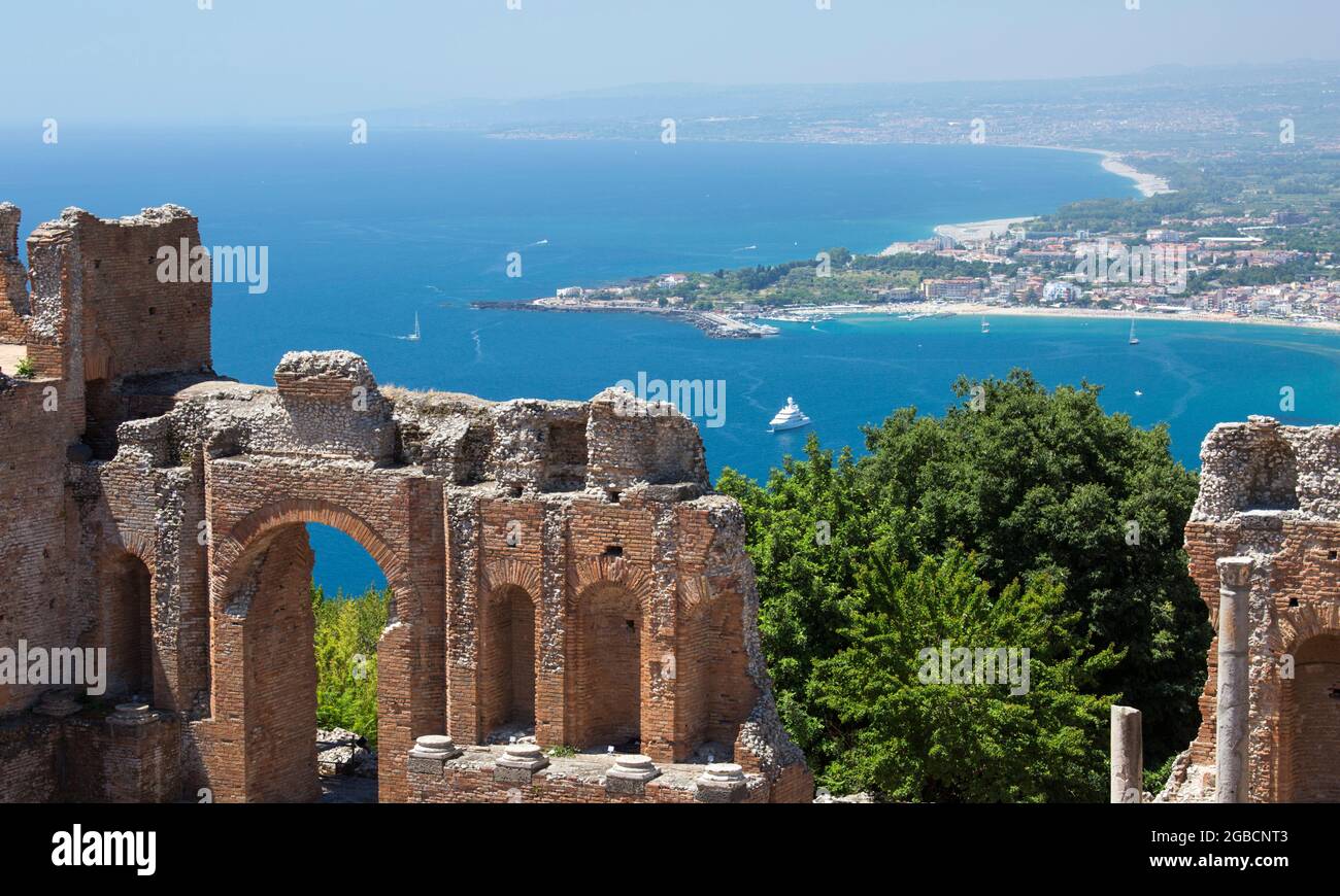 Taormina, Messina, Sizilien, Italien. Blick vom Griechischen Theater über das türkisfarbene Wasser der Bucht von Naxos auf das ferne Giardini-Naxos. Stockfoto