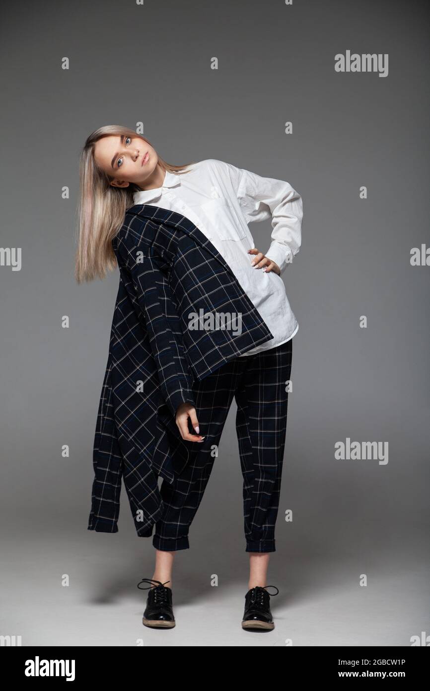 Frau in stilvollem Outfit im Studio stehend Stockfoto