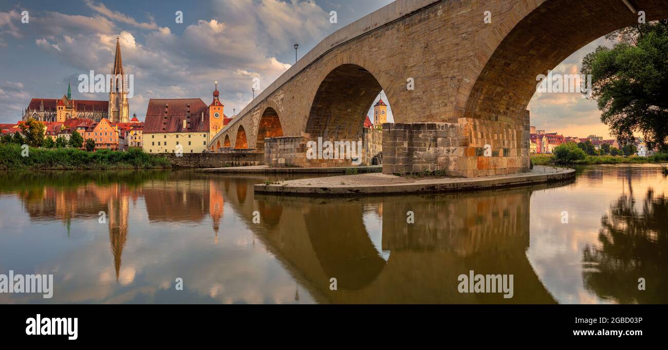 Regensburg, Deutschland. Panoramabild von Regensburg, Deutschland mit der alten Steinbrücke über die Donau und dem Petersdom bei Sonnenuntergang im Sommer. Stockfoto
