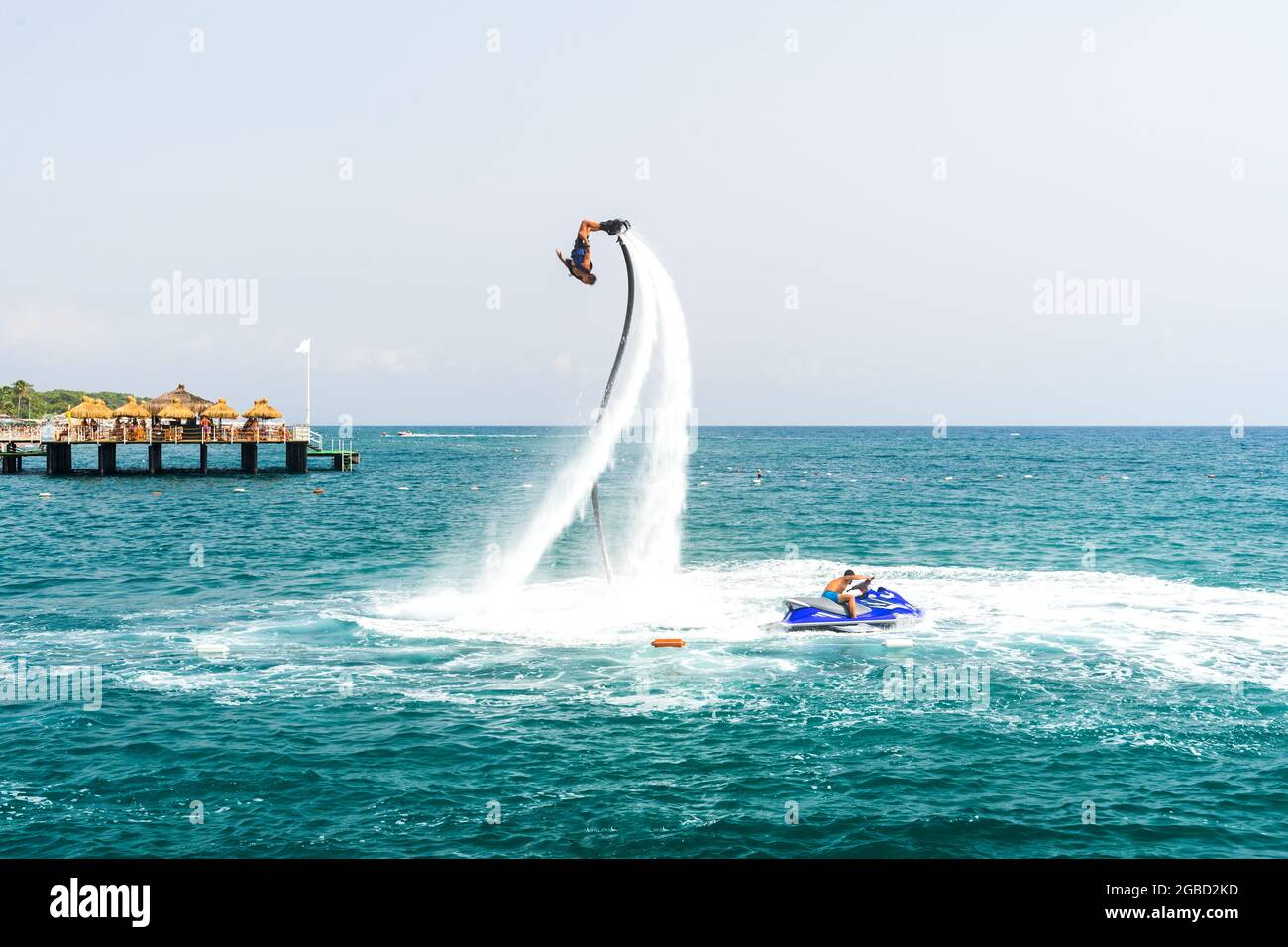 Ein extremer Wassersport. Ein Kerl macht Flip Tricks auf einem Wasser-Flyboard. Extremurlaub am Meer. Stockfoto