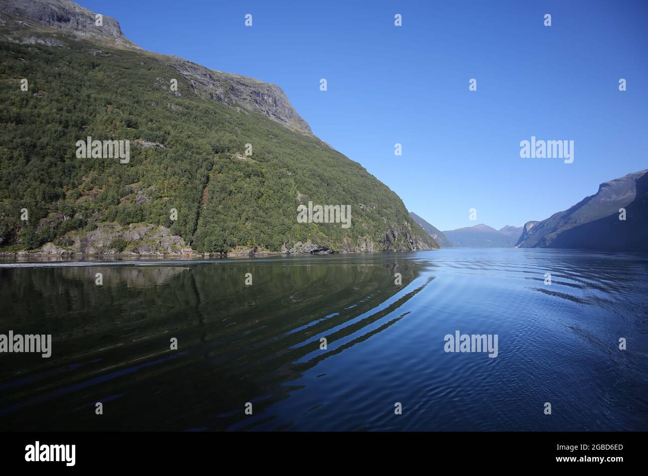 Landschaftlich reizvolle Fahrt auf dem Geiranger Fjord. Schöne Landschaft mit Reflexionen der Berge an einem ruhigen Sommertag, norwegischen Fjorden, Norwegen. Stockfoto