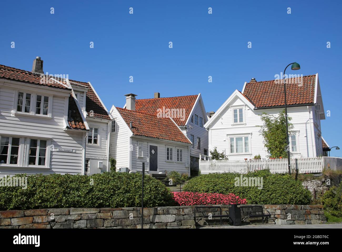 Traditionelle Holzhäuser, die weiß mit roten Dächern gestrichen sind. Das Hotel liegt in Gamle Stavanger, einem historischen Viertel der Stadt Stavanger, Norwegen. Stockfoto