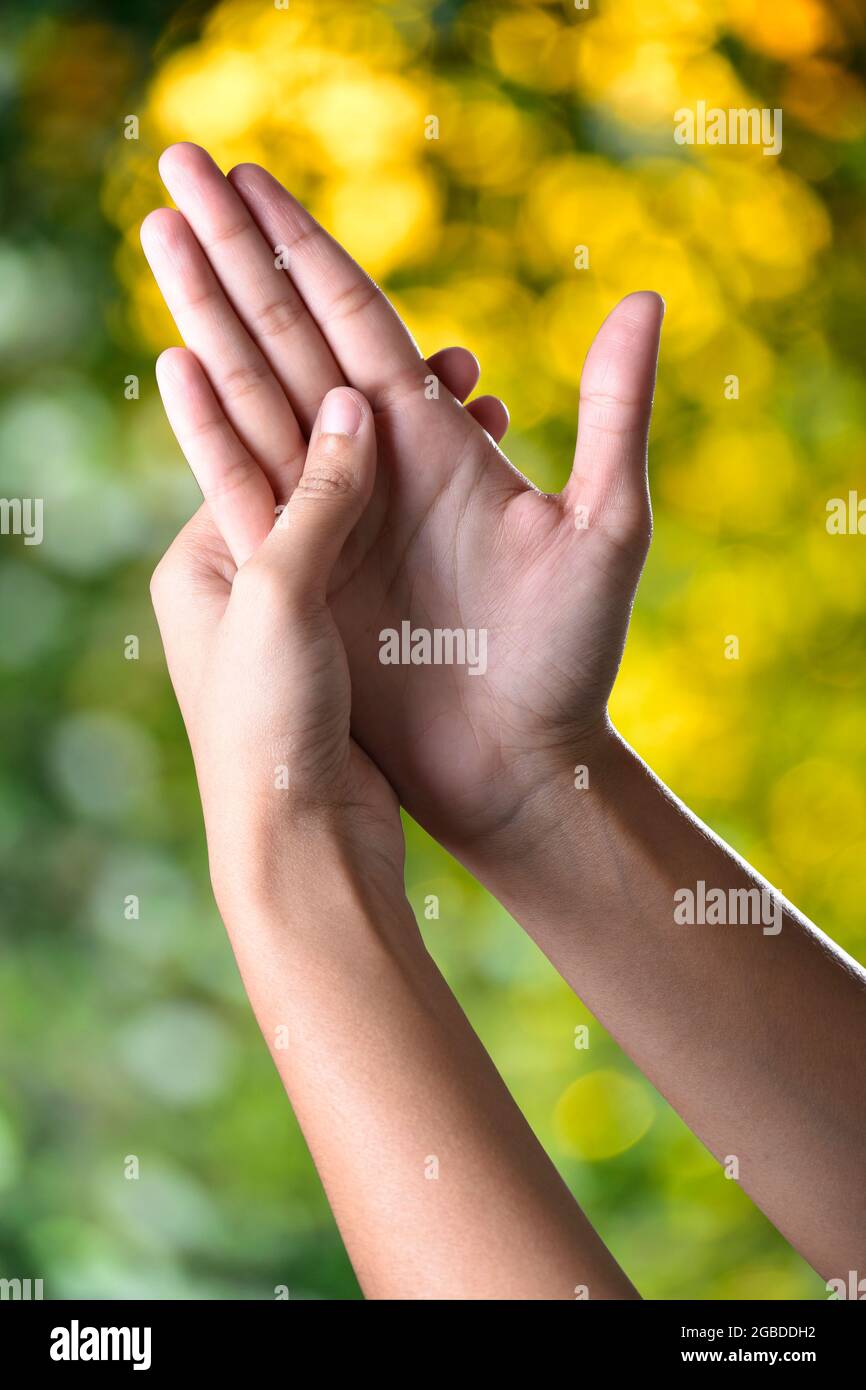 Schöne weibliche Hände machen Akupressur auf Sonnenlicht im Freien, Akupressur Alternative Therapie für schwaches Sehvermögen und Angst Stockfoto